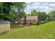Expansive backyard showing the home, deck, shed, lush greenery, and mature trees at 11701 Brockley Ct, Charlotte, NC 28215