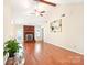 Spacious living room features hardwood floors, a ceiling fan, and a cozy brick fireplace at 11701 Brockley Ct, Charlotte, NC 28215
