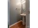 Small half bathroom featuring a pedestal sink, wood-look floors, and brushed nickel hardware at 118 Barnhardt Loop, Mooresville, NC 28117