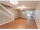 Neutral-toned living room with wood-look floors, stair access, and sliding glass door leading to the patio at 118 Barnhardt Loop, Mooresville, NC 28117