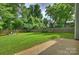 Expansive backyard featuring a lush lawn, mature trees, and a tranquil seating area at 1209 Leigh Ave, Charlotte, NC 28205