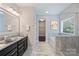 Bathroom featuring double vanities, soaking tub and a separate shower with backyard views at 1209 Leigh Ave, Charlotte, NC 28205