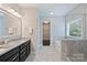 Bathroom featuring a double sink vanity, soaking tub, and tiled floors at 1209 Leigh Ave, Charlotte, NC 28205