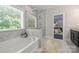 Bright bathroom with a tub, separate shower, and backyard views at 1209 Leigh Ave, Charlotte, NC 28205