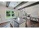 Bright kitchen featuring a center island with bar seating, stainless appliances, and a view of the backyard at 1209 Leigh Ave, Charlotte, NC 28205