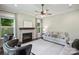 Cozy living room featuring a fireplace, ceiling fan, gray sofa, and two black chairs with studded detail at 1209 Leigh Ave, Charlotte, NC 28205