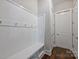 Mudroom with hooks, a bench and storage space, all in white at 1209 Leigh Ave, Charlotte, NC 28205