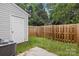 Backyard area with a white storage building, wooden privacy fence, grass and an AC unit at 13660 Meade Glen Ct, Charlotte, NC 28273