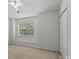 Bright bedroom featuring a ceiling fan, a window and neutral carpet with a closet for storage at 13660 Meade Glen Ct, Charlotte, NC 28273
