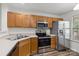 Efficient kitchen features stainless steel appliances and warm wood cabinets at 13660 Meade Glen Ct, Charlotte, NC 28273