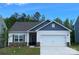 Charming single-story home with a two-car garage, stone accents, and vinyl siding against a clear blue sky at 1528 Doran Ter, Richburg, SC 29729