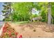 Scenic backyard with lush lawn, blooming flower beds, and mature trees leading to the tranquil lake at 16317 Terry Ln, Huntersville, NC 28078