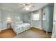 Well-lit bedroom boasts a patterned bedspread, ceiling fan, and bright window at 16317 Terry Ln, Huntersville, NC 28078