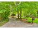 Long, paved driveway through lush greenery leads to a beautiful home, showcasing curb appeal at 16317 Terry Ln, Huntersville, NC 28078