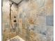 Modern shower featuring decorative stone tile, rainfall shower head, and bronze fixtures at 16317 Terry Ln, Huntersville, NC 28078