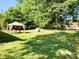 Relaxing backyard with mature trees, a storage shed, and a gazebo with chairs at 1750 Sells Rd, Salisbury, NC 28144