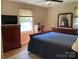 Well-lit bedroom showcasing a dark wood dresser and bedframe complemented by a blue quilt and light carpet at 1750 Sells Rd, Salisbury, NC 28144