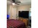A contemporary bedroom design with a large TV and unique red and black patterned quilt at 1750 Sells Rd, Salisbury, NC 28144