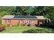 Charming brick home with purple shutters, solar panels, and a well-maintained lawn in a quiet neighborhood at 1750 Sells Rd, Salisbury, NC 28144