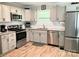 Updated kitchen with stainless steel appliances, sleek white cabinets, and stylish subway tile backsplash at 1750 Sells Rd, Salisbury, NC 28144