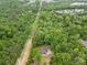 Expansive aerial view of wooded acreage featuring a charming brick home surrounded by mature trees and an access easement at 1792 Hoffman Rd, Gastonia, NC 28054