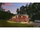 Brick home with dual wooden decks, mature trees, and landscape lighting at dusk at 1792 Hoffman Rd, Gastonia, NC 28054