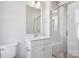 A bright bathroom with a glass-enclosed shower, white vanity, and neutral tile accents at 2013 Clarksdale Dr # 38, Charlotte, NC 28206
