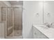 A bright bathroom with a glass-enclosed shower, white vanity, and neutral tile accents at 2013 Clarksdale Dr # 38, Charlotte, NC 28206