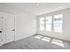 Sunlit bedroom with plush gray carpet, multiple windows, and modern white doors and trim at 2013 Clarksdale Dr # 38, Charlotte, NC 28206