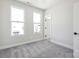 Bright bedroom features neutral gray carpet, two windows, and white walls at 2013 Clarksdale Dr # 38, Charlotte, NC 28206