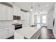Bright kitchen features a center island, modern appliances, and white cabinetry against dark wood floors at 2013 Clarksdale Dr # 38, Charlotte, NC 28206