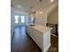 Kitchen island with stainless steel sink, white cabinets, quartz countertops, and pendant lighting at 2013 Clarksdale Dr # 38, Charlotte, NC 28206
