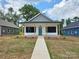 Charming new construction home featuring a covered front porch, teal front door, and minimalist landscaping at 213 Benfield Rd, Kings Mountain, NC 28086