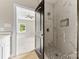 Marble tiled shower with black accent tiles and matte black hardware, adjacent to a bedroom at 213 Benfield Rd, Kings Mountain, NC 28086