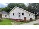 Side view of a quaint house with white siding, red brick foundation, and a small, well-kept yard at 2328 Milton Ave, Gastonia, NC 28052
