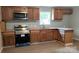 Traditional kitchen featuring wood cabinets, modern stainless steel appliances, and ample counter space at 2328 Milton Ave, Gastonia, NC 28052