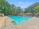 Large community pool surrounded by trees and ample deck space at 2635 Cotton Planter Ln, Charlotte, NC 28270