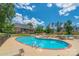 Community pool area with lounge chairs and umbrellas, featuring a large building and mature trees in the background at 282 Fischer Rd, Fort Mill, SC 29175