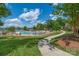 A community pool surrounded by lush landscaping, lounge chairs, and a lake in the background at 282 Fischer Rd, Fort Mill, SC 29175