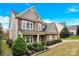 Charming two-story home with stone and wood facade, lush landscaping, and inviting front entrance at 282 Fischer Rd, Fort Mill, SC 29175