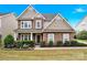 Charming two-story home with stone and wood facade, lush landscaping, and inviting front entrance at 282 Fischer Rd, Fort Mill, SC 29175