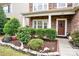 Landscaped front yard with stone edging, bushes, and walkway to brown front door with festive wreath at 282 Fischer Rd, Fort Mill, SC 29175