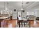 Open kitchen dining area with modern lighting, island seating, and hardwood floors at 282 Fischer Rd, Fort Mill, SC 29175