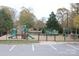 A well-maintained playground featuring a variety of play structures, surrounded by trees and a black metal fence at 282 Fischer Rd, Fort Mill, SC 29175