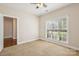 This bedroom features neutral carpet, one window with blinds, and a doorway to the hallway at 2910 Lake James Ct, Monroe, NC 28110