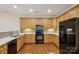Well-lit kitchen with stainless steel appliances, wood cabinets, and hardwood flooring at 2910 Lake James Ct, Monroe, NC 28110