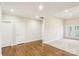 Open-concept living area with hardwood floors, and natural light from the many surrounding windows at 2910 Lake James Ct, Monroe, NC 28110