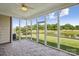 The sunroom features brick flooring, screens overlooking a serene pond with a fountain, and a ceiling fan at 2910 Lake James Ct, Monroe, NC 28110