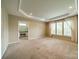 Main bedroom featuring carpet floors, tray ceilings, and lots of natural light at 3043 Santee Ct, Fort Mill, SC 29707