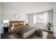 Staged bedroom featuring a large bed, wood floors, and a window at 3109 Heathstead Pl, Charlotte, NC 28210